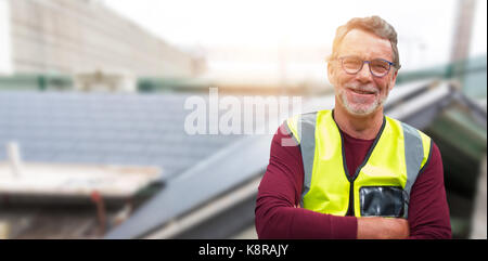 Close up portrait of senior worker wearing reflective clothing against workshop Stock Photo
