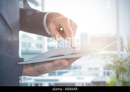 Mid section of businessman using tablet against working desk in a office Stock Photo