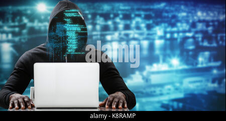 Male hacker using laptop on table against high angle view of crowded buildings in city Stock Photo