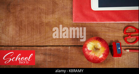 Back to school text over white background against overhead view of apple with ruler and tablet Stock Photo