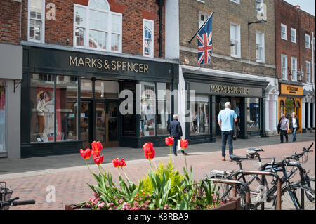 People wealk along North Street and past a Marks & Spencer store on a sunny day in Chichester, West Sussex, England, UK. Stock Photo