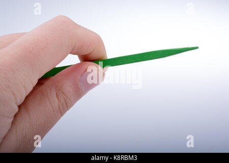 Little wooden sharp stick in hand on white background Stock Photo