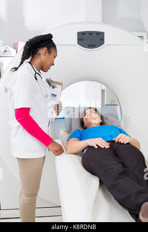Female Radiologist Looking At Patient Undergoing MRI Scan Stock Photo