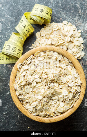 Oat flakes in bowl and measuring tape. Diet concept. Stock Photo
