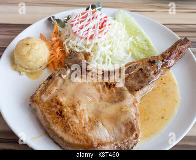 Pork chops steak with the gravy sauce on the white plate in the local restaurant. Stock Photo