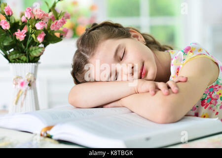 little cute girl falling asleep on book Stock Photo