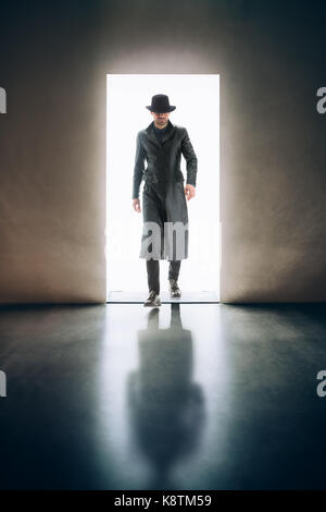 Man silhouette coming from the light of opening door in dark room. mystery concept Stock Photo