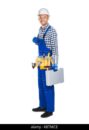 Full length portrait of smiling construction worker in uniform with toolbox isolated on white background Stock Photo