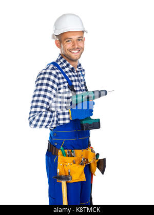 Smiling construction worker with drill and tool belt isolated on white background Stock Photo