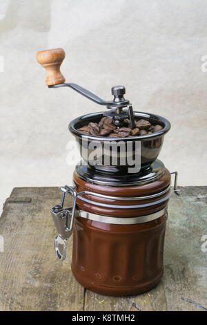 Freshly medium roasted Araica coffee beans in a manual coffee grinder Stock Photo