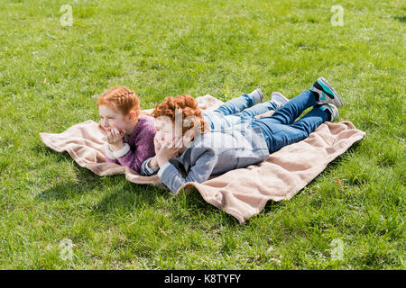 siblings lying on grass  Stock Photo