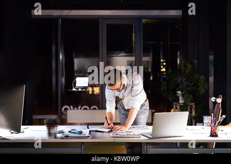 Businessman in the office at night working late. Stock Photo