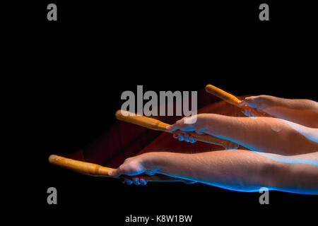 The arm with wooden baseball bat on black background Stock Photo