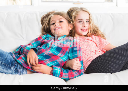 happy little girls lay on sofa Stock Photo