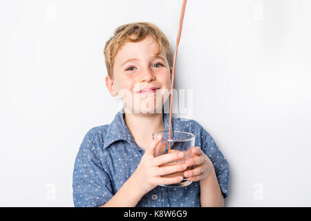 Happy smiling child drinking chocolate milk isolated on white Stock Photo