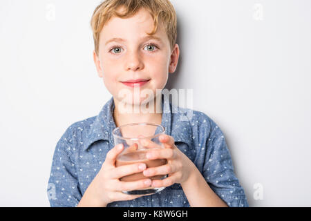 Happy smiling child drinking chocolate milk isolated on white Stock Photo