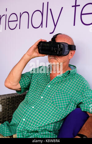 Senior male at a Telus Mobility booth using Samsung Oculus Gear VR headset, metaverse virtual reality technology googles in London, Ontario, Canada. Stock Photo