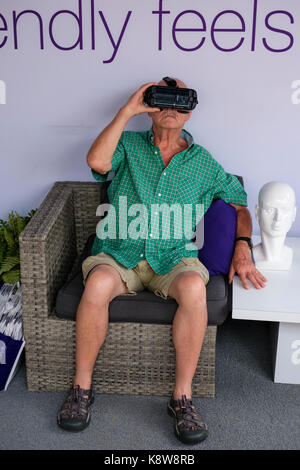 Senior male at a Telus Mobility booth using Samsung Oculus Gear VR headset, metaverse virtual reality technology googles in London, Ontario, Canada. Stock Photo