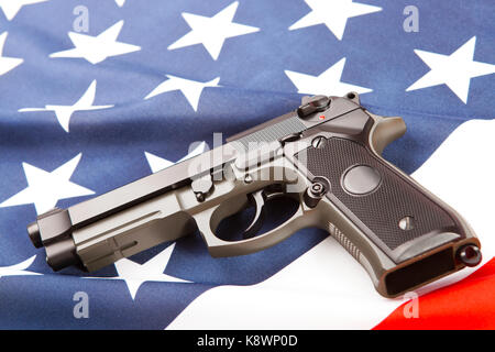 Handgun lying on satin USA flag - studio shoot Stock Photo