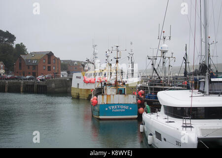 Fishing boats, docked in Padstow Harbour, on an overcast day. Harriet Baggley Stock Photo