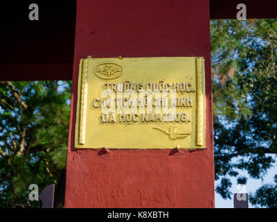 Hue, Vietnam - September 13 2017: Informative sign in a yellow plate over a orange colum, in the city of Hue, Vietnam Stock Photo