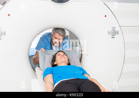 Doctor Preparing Patient For CT Scan In Hospital Stock Photo