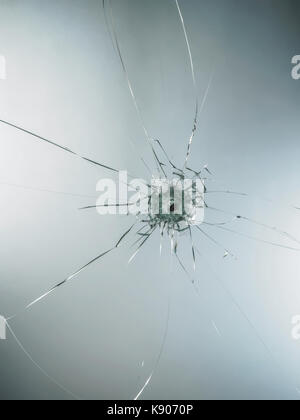 Bullet Hole in glass isolated on white background. Stock Photo