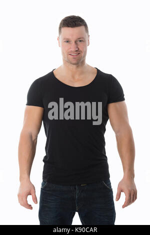 Handsome mid adult man in black tshirt standing with hands in pockets against white background Stock Photo
