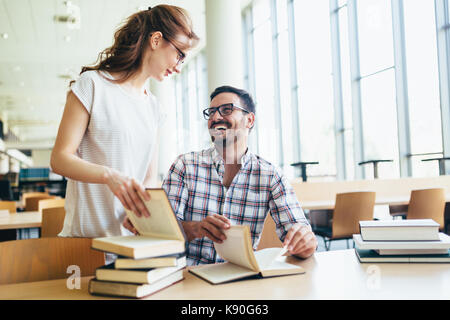 Young attractive students spending time in library Stock Photo