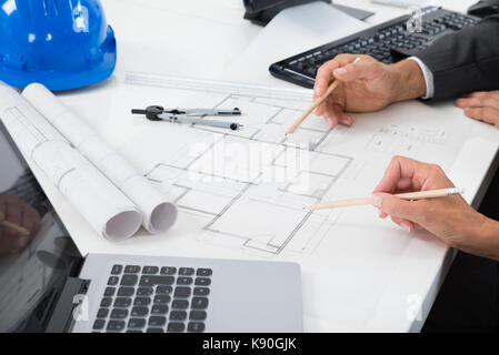 Close-up Of Two Architects Hands Working On Blueprint Stock Photo