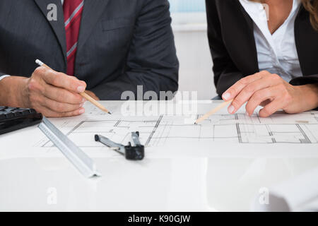 Close-up Of Two Architects Hands Working On Blueprint Stock Photo