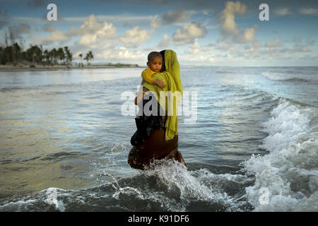 Teknaf, Bangladesh. 14th Sep, 2017. A Myanmar Rohingya refugee woman holds her son after arriving on a boat to Bangladesh on Shah Porir Dip Island. According to United Nations more than 300 thousand Rohingya refugees have fled Myanmar from violence over the last few weeks, most trying to cross the border and reach Bangladesh. International organizations have reported claims of human rights violations and summary executions allegedly carried out by the Myanmar army. Credit: K M Asad/zReportage.com/ZUMA Wire/Alamy Live News Stock Photo