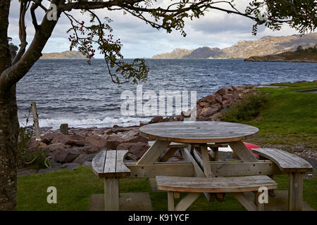 Looking north west from Shieldaig across Loch Shieldaig. Wooden picnic table and benches in foreground. Ross and Cromarty, Scotland Stock Photo