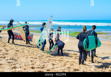 ERICEIRA, PORTUGAL - JUL 23, 2017: Group of surfers with surfboards going to surfing. Ericeira is the famous surfing destination in Portugal. Stock Photo