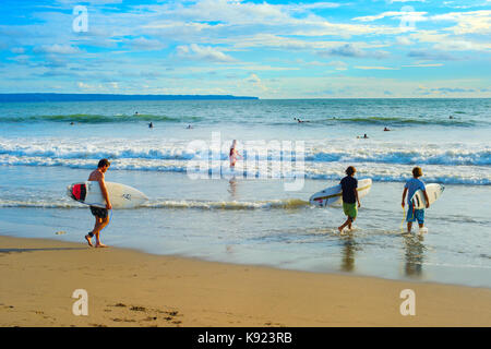 CANGGU, BALI ISLAND, INDONESIA - JAN 19, 2017: Group of surfers going to surf on the beach. Bali island is one of the worlds best surfing destinations Stock Photo