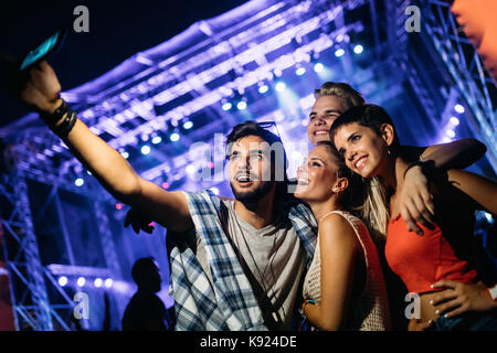 Happy friends taking selfie at music festival Stock Photo