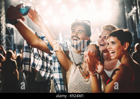 Happy friends taking selfie at music festival Stock Photo