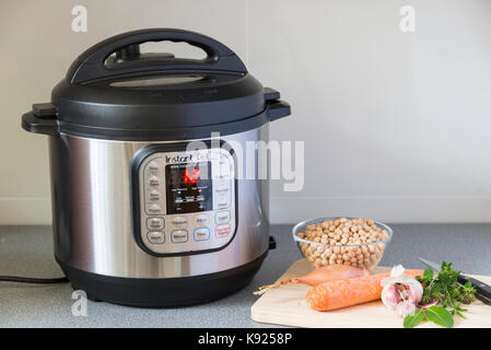 An Instant Pot Electric Pressure Cooker in use in a kitchen. Stock Photo