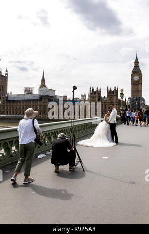 London, UK - August 14, 2017: Asian new married couple have their wedding photos taken in front of Westminster Palace Stock Photo