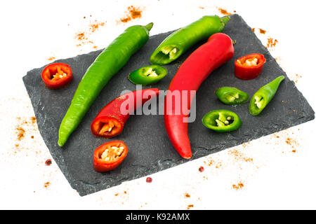Colored chilli peppers on black stone. Studio Photo Stock Photo