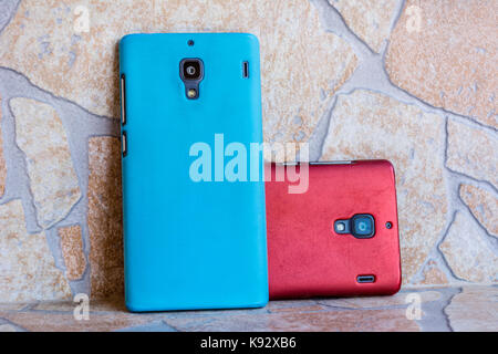 Two smart-phones red and blue color right angle view Stock Photo