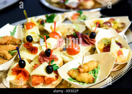 Home made canapes small sandwiches appetizers. Mix of different finger food snacks for a party or banquet on a plate. Stock Photo