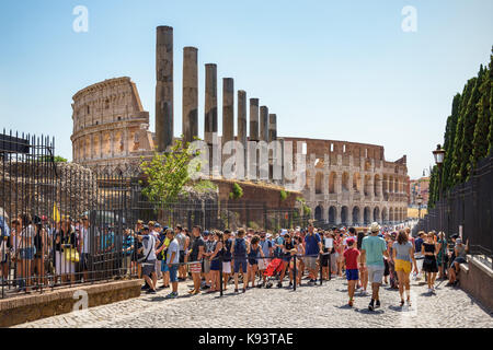 Hordes of tourists queuing on Via Sacra to enter the forum, Colosseum in background, Rome, Italy Stock Photo