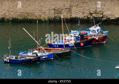 Small inshore fishing boats aligned by the tide in Mevagissey harbour, Cornwall, UK Stock Photo