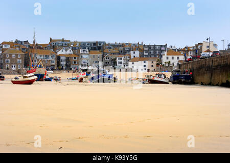 Fishing and pleasure boats beached on the strand at St Ives, Cornwall, at low tide Stock Photo