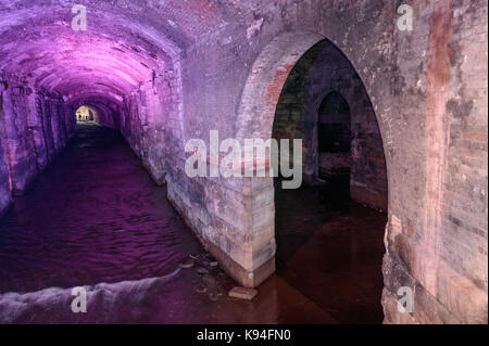 The River Aire passing under Leeds City train station, through an area known as the dark arches. Stock Photo