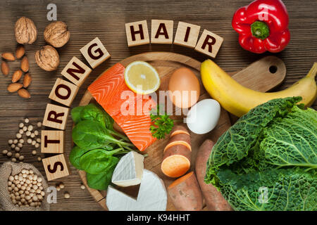 Healthy hair concept. Best foods for healthy hair as salmon, spinach, almonds, sweet potatoes, eggs, walnuts, cabbage, cheese, red pepper, banana and  Stock Photo