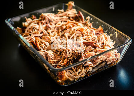 Pulled pork from oven in glass bowl ready for serving. Home made pulled pork made in house oven, smoker or barbecue bbq is ready to be eaten. Stock Photo