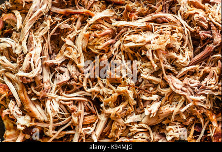 Pulled pork from oven in glass bowl ready for serving. Home made pulled pork made in house oven, smoker or barbecue bbq is ready to be eaten. Stock Photo