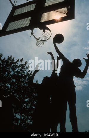 Players fighting for a rebound during street basketball game in 'the cage' in New York City's Greenwich Village, 1978 Stock Photo